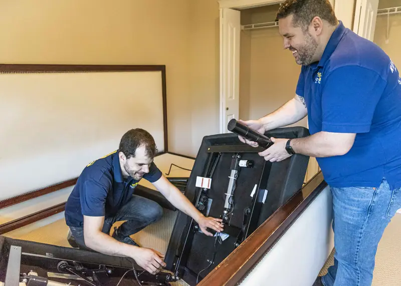 Movers assembling a bed frame