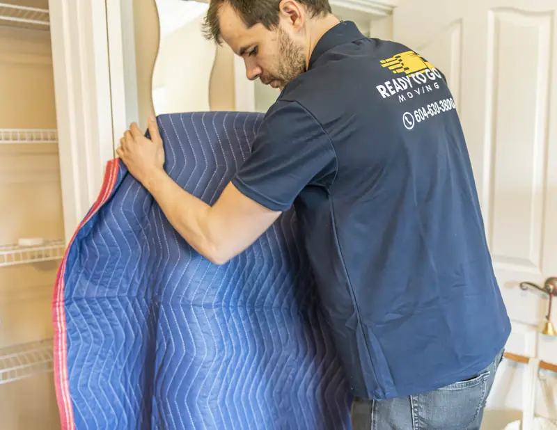 Mover wrapping furniture in blankets